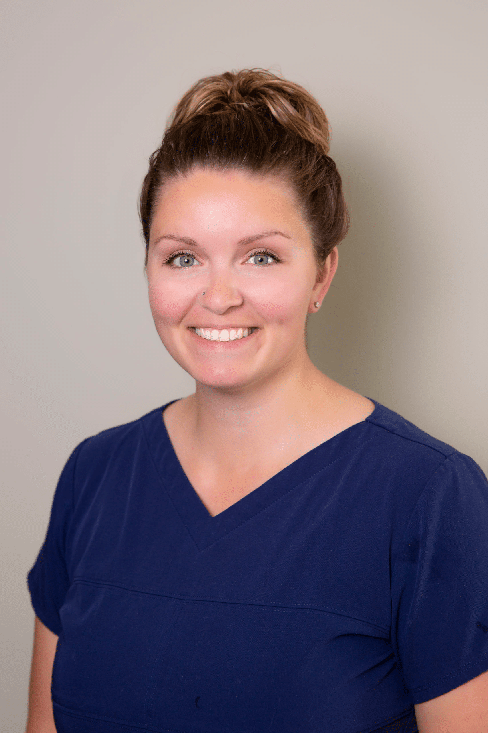 Amanda, a staff member of Dr. Gary Wessels Inc., has long brown hair and is wearing a blue shirt.