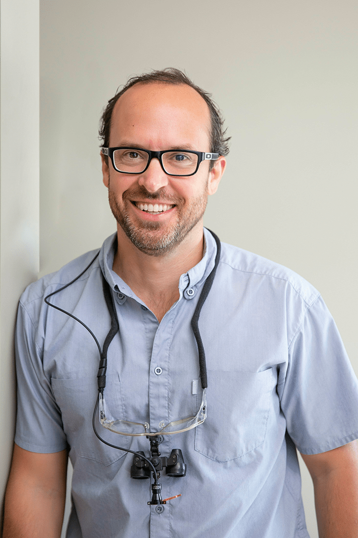 Dr. Gary Wessels, a man in glasses and a blue shirt, poses for a headshot with a friendly expression.