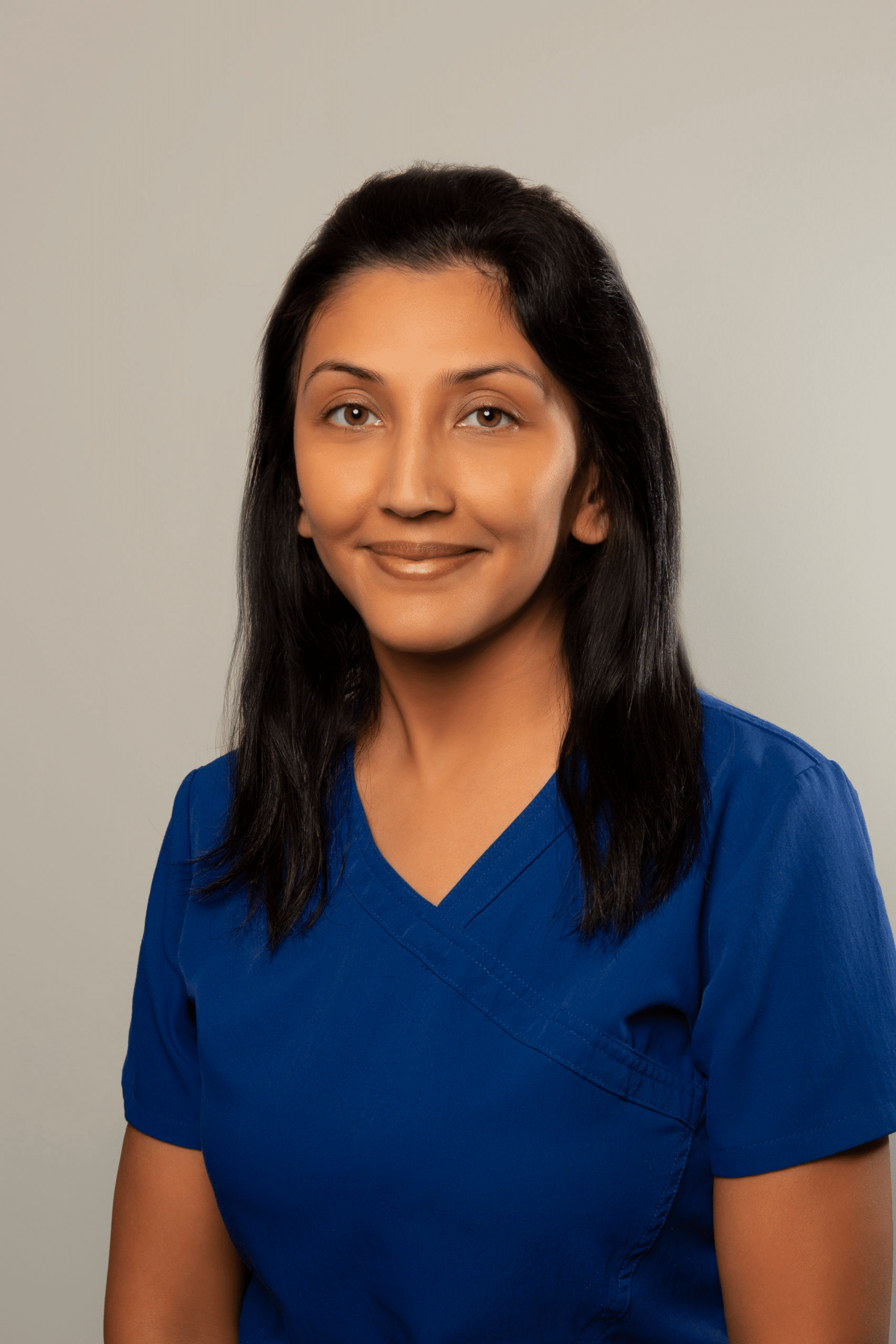 A woman with long brown hair wearing a blue shirt, identified as Liza, staff member of Dr. Gary Wessels Inc.